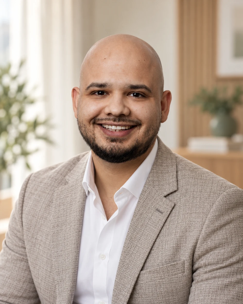 Emre Bayram lächelt in einem hellen Blazer